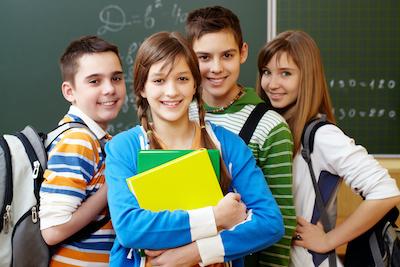 group of kids standing infront of a chalk board