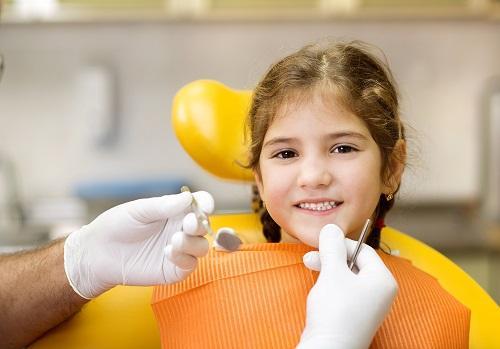 young girl smiling in dental chair after getting prompt emergency care in eagle river