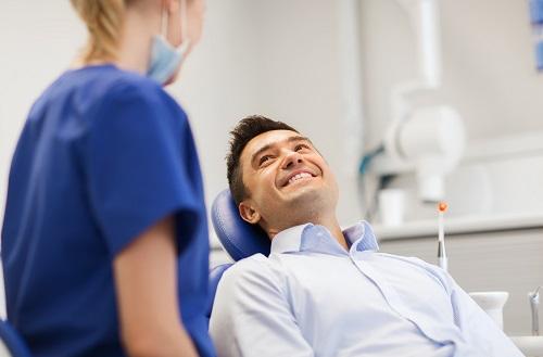 man sitting in dental chair smiling 