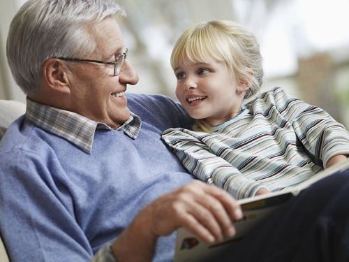 Grandpa reading a book to his granddaughter