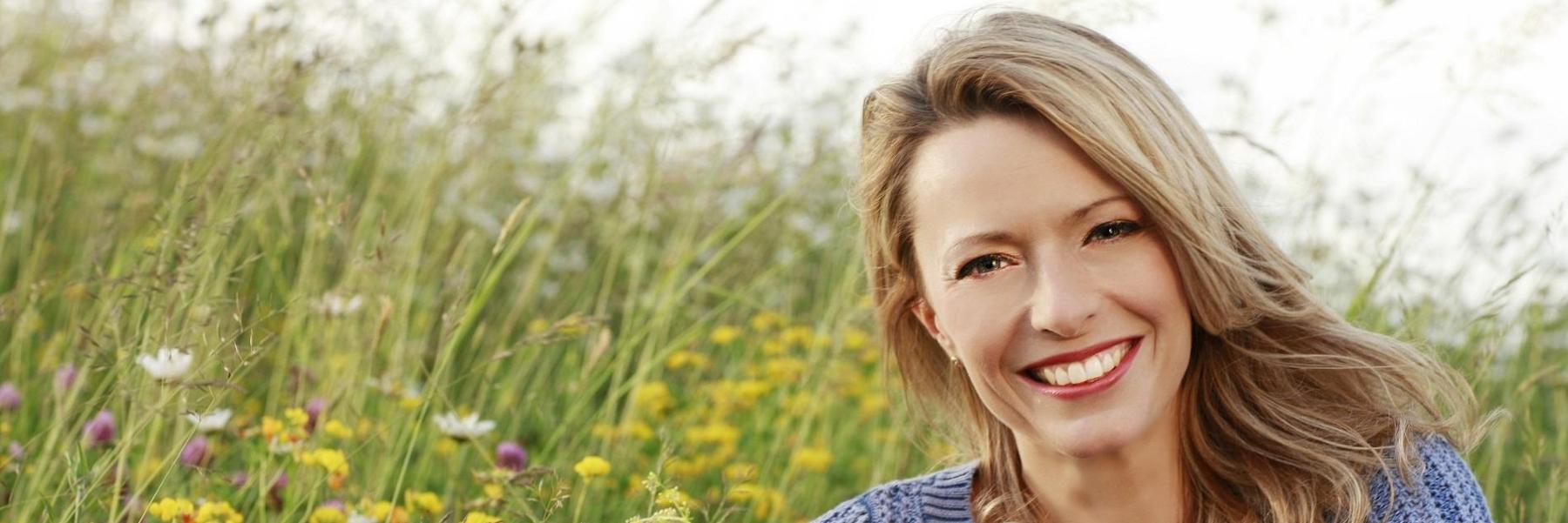 woman smiling in field of wildflowers 